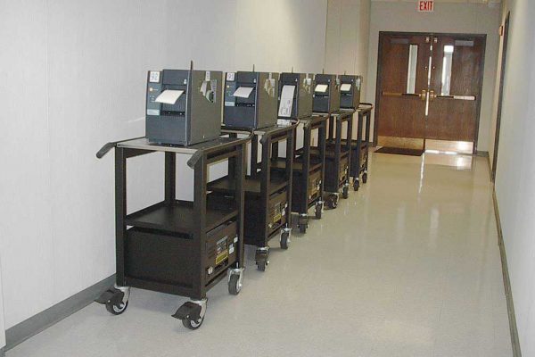 Five of our powered carts for automotive in a row in front of a door.