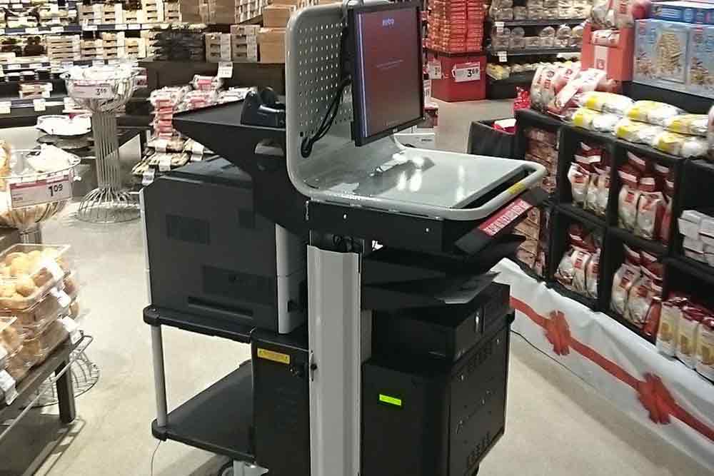 A powered cart for retail in the middle of a grocery store being used for inventory tracking and printing.